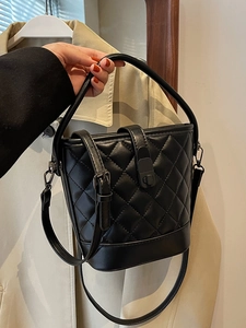 Classic black quilted bucket bag with top handle and adjustable crossbody strap for women