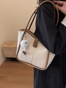 Minimalist cream and brown tote bag for women with a cute white plush charm on a shoulder strap