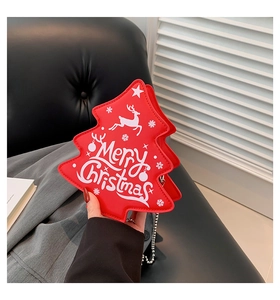 Detail of Christmas tree shaped red PU leather bag with festive Merry Christmas print