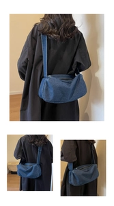 Macro detail of dark blue washed denim crossbody bag featuring durable zip closure