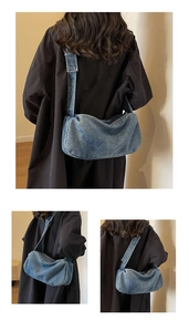 Detailed close-up showing blue denim pillow bag texture and adjustable wide metal eyelet strap