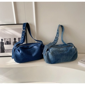 Detail of blue denim pillow bags with adjustable metal eyelet wide shoulder straps