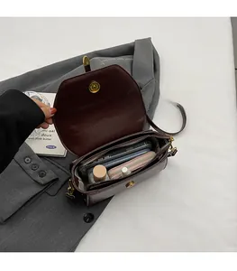 Interior view showing the spacious storage compartment of the brown crossbody bag