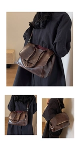 Detail view of coffee brown retro messenger bag with polished faux leather and wide strap