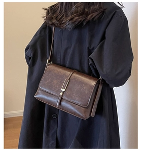 Vue latérale d'un sac à bandoulière vintage en cuir huilé marron avec fermoir doré