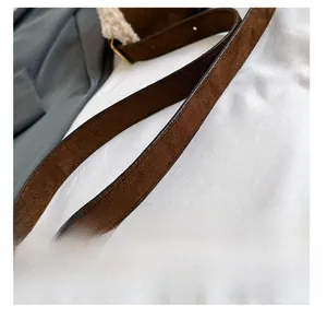 Détail de la bandoulière en daim marron avec boucle en métal bronze vintage