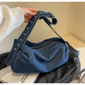 Detail of vintage denim pillow bag with thick cotton fabric and silver metal eyelets