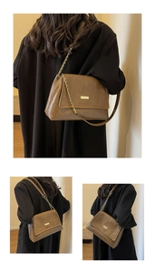Detail shot of a brown vintage tote bag with gold metal buckle and chain strap