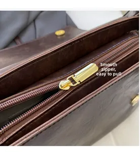 Gros plan sur la fermeture éclair dorée et le fermoir magnétique d'un sac en cuir brun
