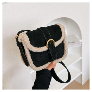 Détail d'un sac bandoulière en peluche noire avec bordure en laine crème et boucle dorée