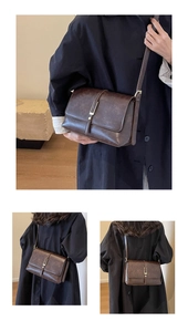 Vue détaillée d'un sac bandoulière vintage marron foncé avec boucle en métal et lanière