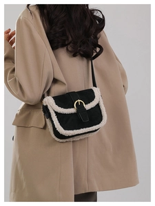 Détail du sac bandoulière en velours noir avec bordure en fourrure sur mannequin en manteau