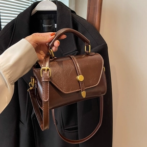 Deep brown vintage leather handbag with gold metal buckle and adjustable strap