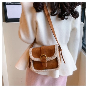 Détail du sac bandoulière en daim caramel avec bordure en fourrure blanche et boucle