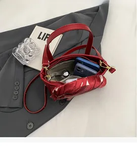 Interior view showing the large capacity of a red bridal bucket bag with two smartphones