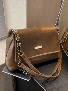 Brown matte leather chain shoulder bag with gold hardware in a minimalist tote design