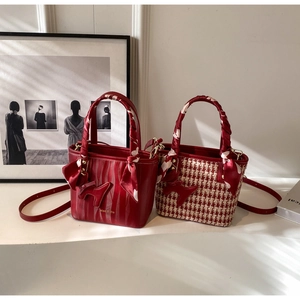 Detail showing two red wedding bucket bags with silk scarves and dog charms