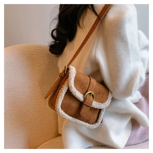 Détail du sac bandoulière vintage en daim marron avec bordure en fourrure blanche et boucle