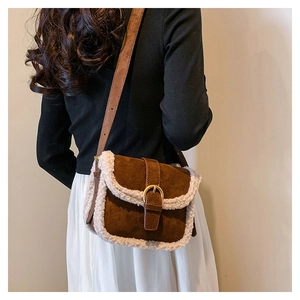 Détail d'un sac bandoulière en daim marron avec bordure en polaire crème sur modèle
