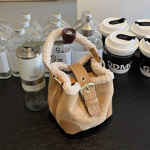 Winter plush bucket bag in khaki suede with white faux fur trim and metal buckle detail