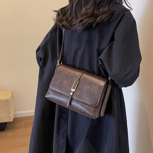 Sac à bandoulière vintage marron foncé minimaliste avec texture cuir et boucle dorée