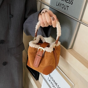 Brown suede bucket bag with white faux fur trim and leather strap shown on a model