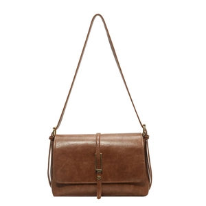 Sac à bandoulière rétro en similicuir marron avec boucle dorée sur fond blanc