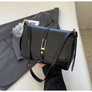 Minimalist black faux leather shoulder bag with golden U-shaped buckle and glossy finish