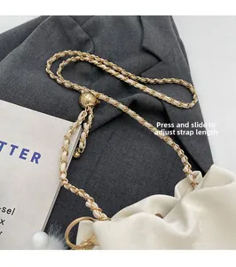 Detail of golden ball slider buckle on cream chain bag for adjustable strap length