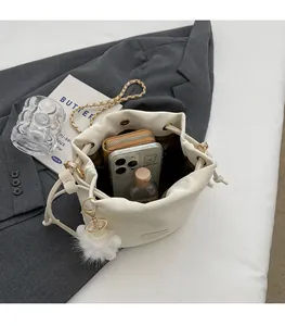 Spacious interior of a cream drawstring bucket bag showing wallet, phone, and skin care