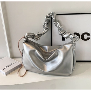Detail of silver pleated handle and metallic faux leather texture on minimalist tote bag