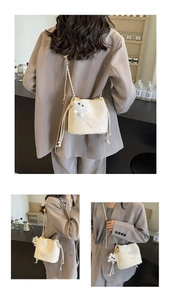 Detailed close-up of a white bucket bag with drawstring closure and golden chain strap