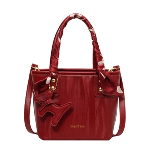 Elegant red bridal bucket bag with wave-embossed leather and decorative silk scarf