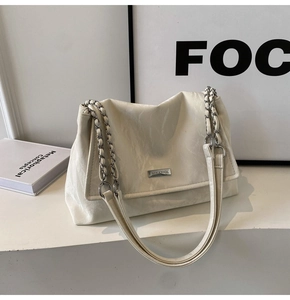 Detail of marble texture leather underarm bag with silver chain strap and logo plate