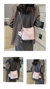 Detail view of pink bucket bag with chain strap, marble texture, and plush bear charm