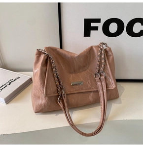 Detailed macro view of pink embossed faux leather texture and silver chain strap