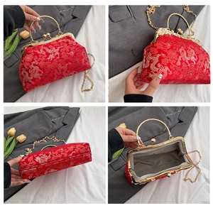 Detail view of red silk embroidery handbag with golden wave handle and spacious interior
