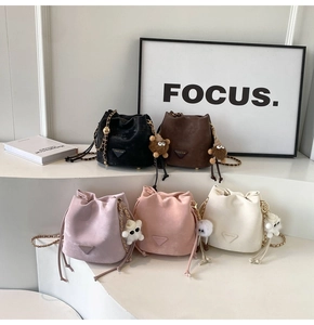 Detailed display of five colors of drawstring bucket bags with chain straps and plush charms