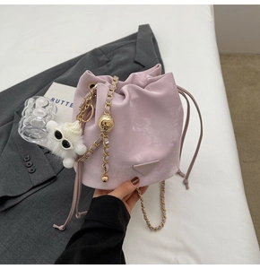 Chic lavender suede bucket bag with gold chain strap and cute white plush pompom charm