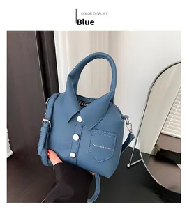Detalle del bolso de hombro azul en cuero granulado con diseño creativo de cuello polo