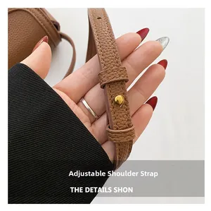 Macro shot of adjustable leather shoulder strap with golden metal buckle for saddle bag