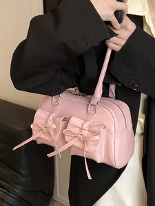 Pink bow shoulder bag with glossy finish and dual front pockets for a stylish look