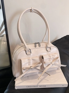 Minimalist cream beige shoulder bag with bow details and glossy finish for women