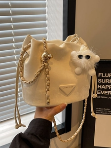 Chic beige bucket bag with gold chain strap, luxury logo plate and cute cloud charm