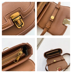Detail view of brown pebbled leather saddle bag showing bronze hardware and zip pocket