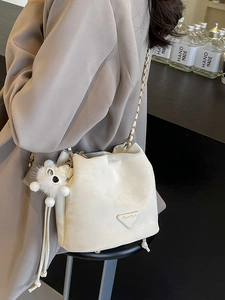 Chic white velvet bucket bag with gold chain strap and plush animal charm detail