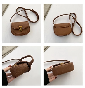 Detail view of brown lychee grain leather saddle bag with gold metal hardware