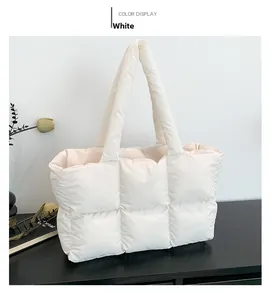 Detail view of the white quilted down tote bag with a soft padded shoulder strap