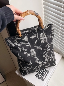 Chic canvas tote with bamboo handles and elegant floral embroidery in a minimalist urban style