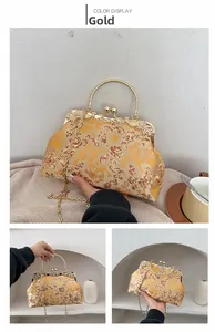 Close-up of golden silk satin shell bag with exquisite dragon and floral embroidery